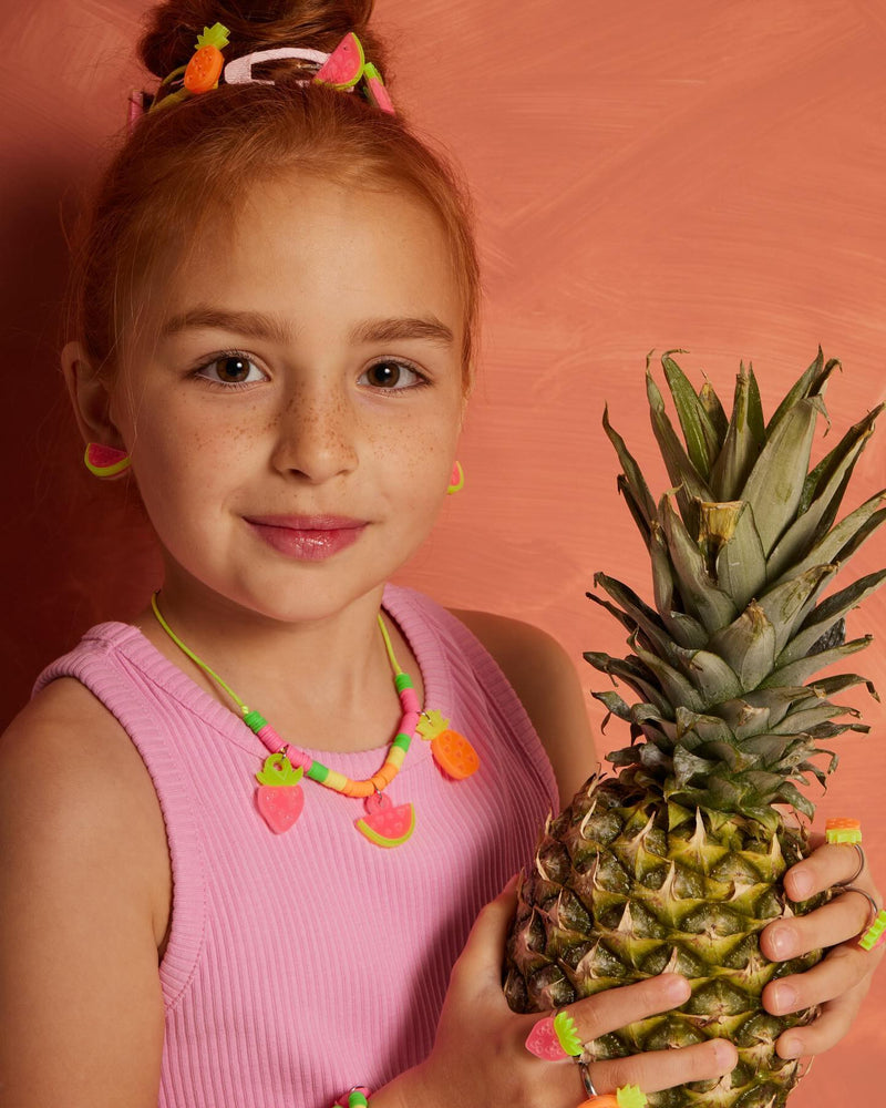 Cute little girl wearing MiniCools Fruit-themed accessories: Colorful hair clips, necklace, rings and bracelets.